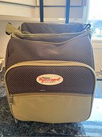 Front view of the Hyannisport Deluxe picnic bag in beige and brown with brand label