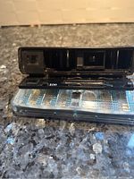 Close-up of camera with flip flash attached showing camera body, lens, and flash bulbs