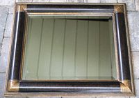 Front view of the rectangular Art Deco mirror showing the full beveled glass and decorative wood frame with dark finish and gold accents in corners.