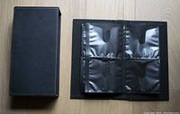 Closed black Case Logic CD storage album with protective case on wooden surface.