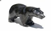 Front three-quarter view of walking polar bear carving on white background