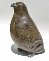 Front left three-quarter view of owl showing body shape, head with carved eyes and wing outline