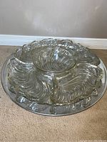 Top view of the silver round serving tray with clear swirl-designed crystal insert in five sections including a center bowl.