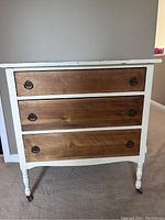 Front view of the vintage 3 drawer dresser showing white painted frame and natural wood drawers with metal ring handles.