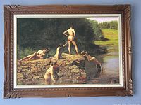 Front view of vintage wooden frame with print of boys swimming on rocks by the water.