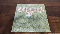 Front cover of Bee Gees Main Course vinyl album showing green patterned background with Bee Gees text and graphic.