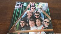Front cover of Madness vinyl album titled 'Madness Is All In The Mind' showing band members' faces arranged behind a pool triangle rack, each member wearing glasses or sunglasses, colorful letters spelling MADNESS on top.
