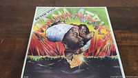Front cover of Peter Tosh Mama Africa vinyl record showing colorful illustration of a woman with headwrap, glowing African continent, and blazing background
