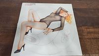 Front cover of The Cars Candy-O vinyl record album showing woman in sheer black bodysuit and high heels on abstract object.