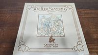 Front cover of the 2-disc vinyl record set 'The Four Seasons Story' by Disques Records with illustrated artwork on a cream background and decorative border.