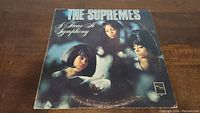 Front cover of The Supremes 'I Hear A Symphony' vinyl album, showing the trio and album title.