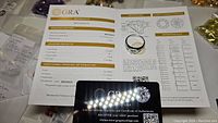 Photo of GRA grading certificate and authenticity card detailing moissanite grading results and certification.