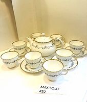 Teapot alongside 8 cups and 6 saucers on display with MAX SOLD tag
