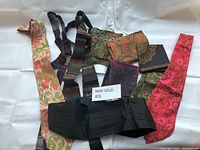 Top view of all items in the lot showing ties, pocket squares, and cummerbund on white background.