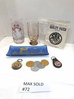 Lot overview showing all items including glasses, tray, keychains, coins, and patch