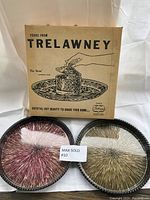 Photo of the vintage Trelawney outdoor serving tray with its original box and two metal starburst trays in red and gold.