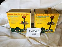 Two original yellow boxes with graphics and text for the twin tier sewing rack, showing box damage.