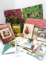 Photo showing an assortment of vintage wrapping paper with various patterns and multiple boxed and loose greeting cards laid out along with decorative stars box.