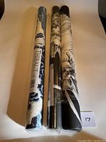 Three wallpaper rolls upright on plain background