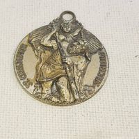 Front view of antique sterling silver St. Christopher medallion showing detailed figure and text