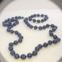 Close-up of dark blue lapis lazuli beads showing their polished surface and natural patterns.