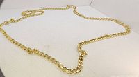 Photo showing the full length of the large gold-tone men’s chain laid out on a flat surface, highlighting the chain link style and absence of a clasp.