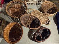 Overview of six woven baskets in various shapes and sizes displayed on a surface.