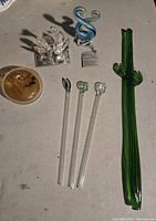 Overview photo showing all six blown glass art pieces including cactus, spoons, swans, and apple on a surface