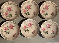 Six J&G Meakin bowls arranged together showing pink rose floral pattern and gold leaf rims