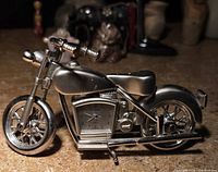 Side view of metal motorcycle model with integrated clock in engine area