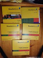 Image of Rosetta Stone Italian language learning software box, user guide, and three audio companion inserts arranged on a wooden surface.