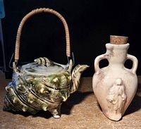 Photo showing both the seashell-shaped teapot and corked jug together on a surface.