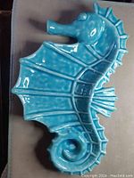 Top view of teal ceramic seahorse platter showing full shape and glossy crazed glaze