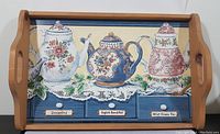 Full view of wood serving tray showcasing the tea time themed artwork with three tea pots and labeled drawers.