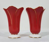 Pair of red Florencia porcelain bud vases with scalloped petal edges, white bases and gold trim, viewed frontally.