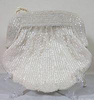 Front view of the vintage evening bag showing the full scalloped shell shape with white bead and sequin decoration.