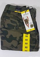 Folded view of the camouflage shorts with size 32 label and original tags attached, showing the brand and product details.