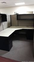 Overview of L-shaped office cubicle showing fabric panels and desk.