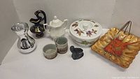 Photo showing all items in the lot including tray, Evesham dish with lid, metal vase, Greek style vase, Wolf seal figurine, and ceramics.