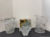 Three glassware items displayed: cut glass pitcher, wavy glass vase, and boxed Mikasa tulip dish.