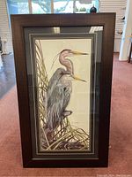 Full view of one framed heron painting showing two herons perched with reeds, signed Cliff S on bottom right, dark wood frame and matting.