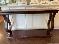 Front view of dark brown wooden sofa table showing overall condition and style