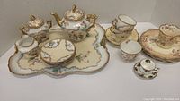 Full view of tea set including tray, teapot, creamer, sugar bowl, cups, saucers, and plates