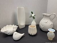 All six white decorative pieces arranged on a black surface showing size and details