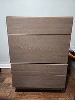 Front view of 3-drawer wooden cabinet showing slight scratch on lower drawer area