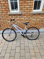 Side view of the white Carrera Evolution adult bicycle with front suspension, shows overall bike profile.