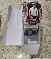 Open box view showing a pile of loose soccer trading cards including visible Mason Mount card from Panini Chronicles Soccer 2022-23 series.