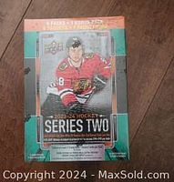 Photo of sealed 2023 Upper Deck Series 2 hockey mega box featuring Chicago Blackhawks player on front and promotional text about contents.