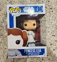 Photo of Funko Pop! Star Wars Princess Leia figure in original box, showing front view of packaged item with branding and character illustration.