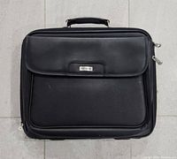 Front view of the black Targus executive laptop bag showing front pocket with brand label and single carry handle on top.